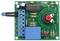 Kit électronique avec circuit intégré, condensateurs, résistances et bornes de connexion bleues sur un circuit imprimé vert.