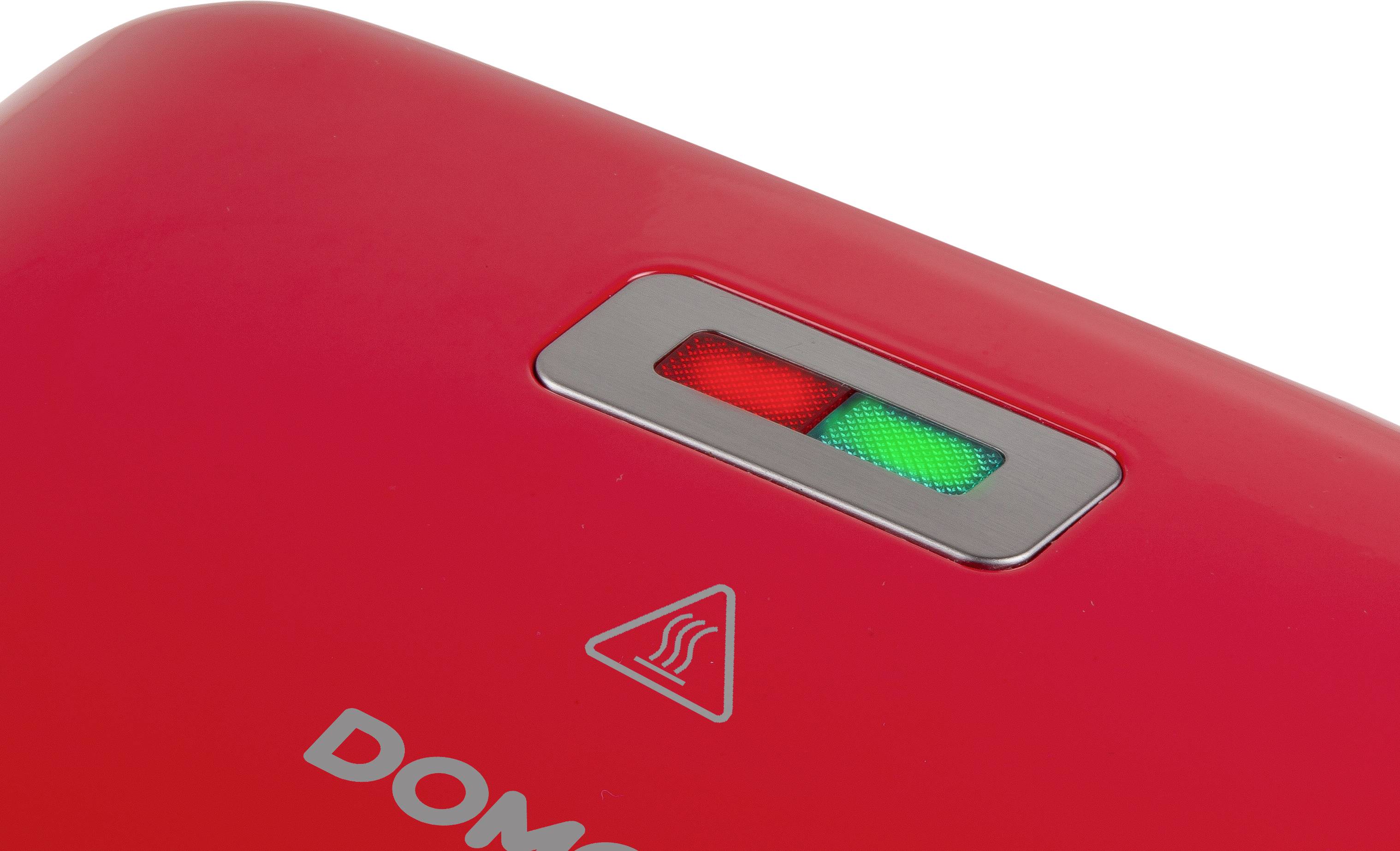 Gros plan d'un appareil de cuisine rouge avec deux voyants : l'un rouge, l'autre vert. Un symbole de chaleur est visible en dessous.