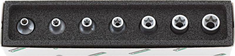 Ensemble de douilles Torx de différentes tailles rangées dans un support en mousse, disposé sur un établi.