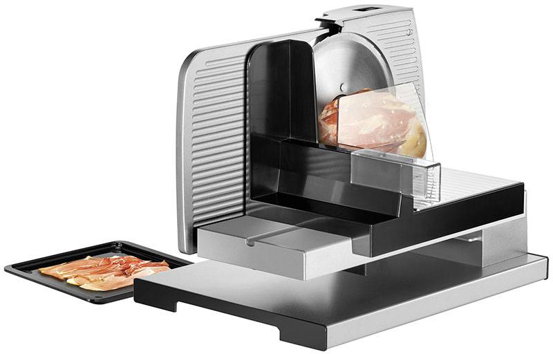 Une machine à trancher électrique avec des tranches de saucisse sur un plateau de réception. L'appareil est en métal et en plastique.