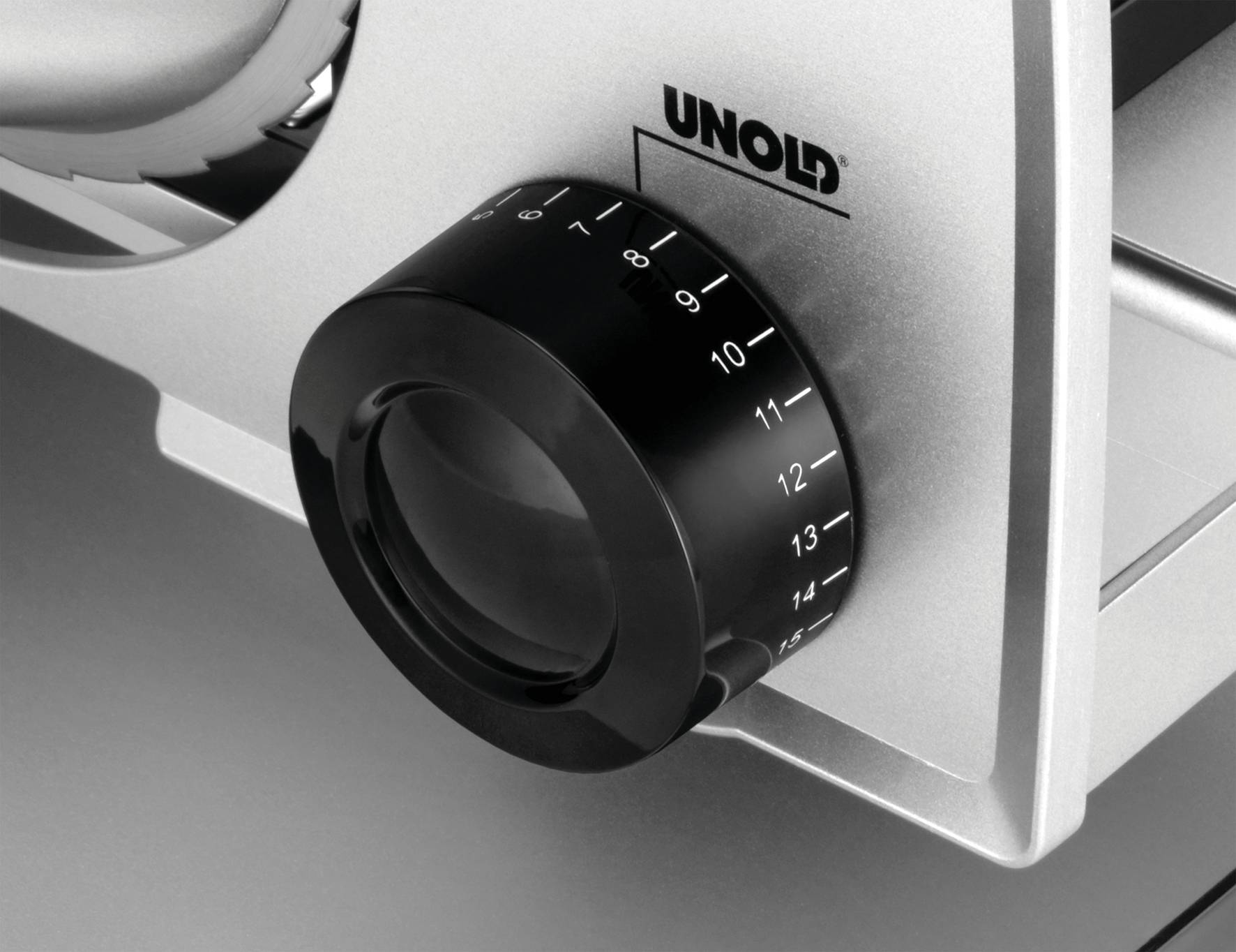 Une machine argentée avec un bouton de réglage noir numéroté de 0 à 15. Le nom de marque 'UNOLD' est inscrit en haut de la façade.