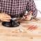 Une personne soude avec un fer à souder sur un haut-parleur. Divers outils et matériaux sont disposés sur une table en bois.