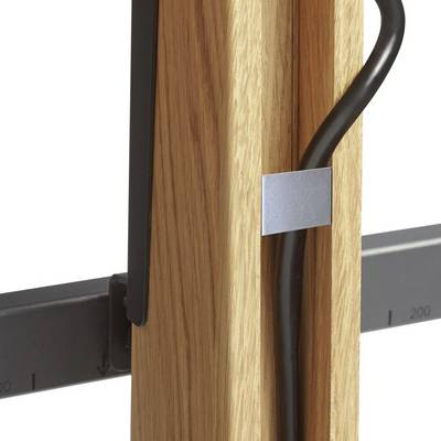 Câble fixé à un cadre en bois à l'aide d'un serre-câble métallique. Un règle avec des indications de mesure est visible à côté.