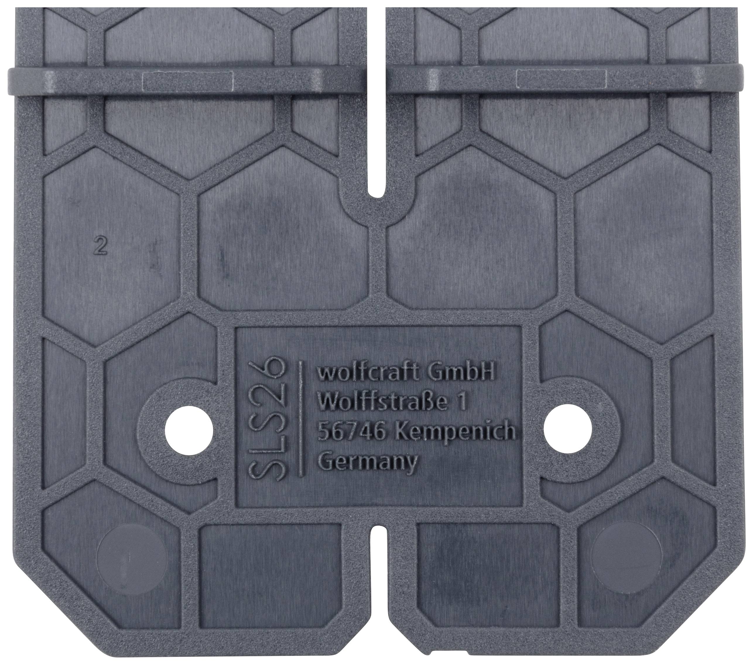 Plaque grise en plastique hexagonale portant l'inscription 'wolfcraft GmbH, Wolffstraße 1, 56746 Kempenich, Allemagne', et marquée 'SLS26'.