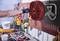 Une personne accroche un tube de rallonge rouge à un support mural dans un atelier. Des outils sont visibles au premier plan.