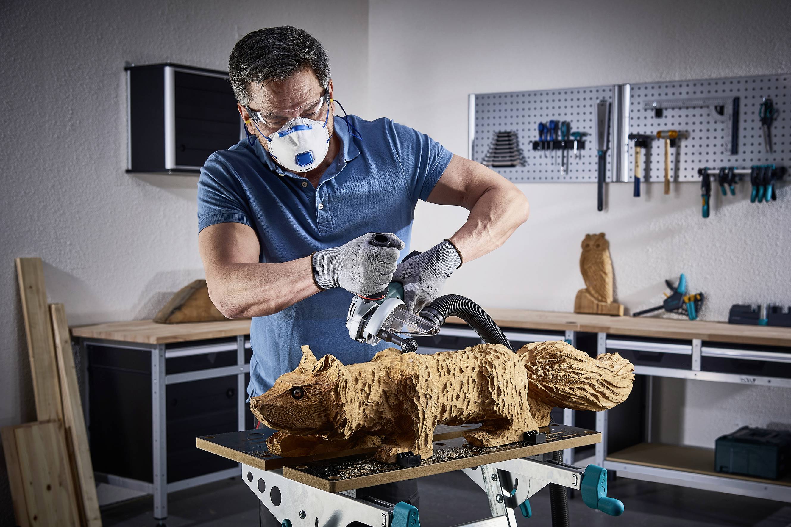 Un homme sculpte méticuleusement un écureuil en bois à l'aide d'une meuleuse électrique. Arrière-plan : environnement d'atelier.