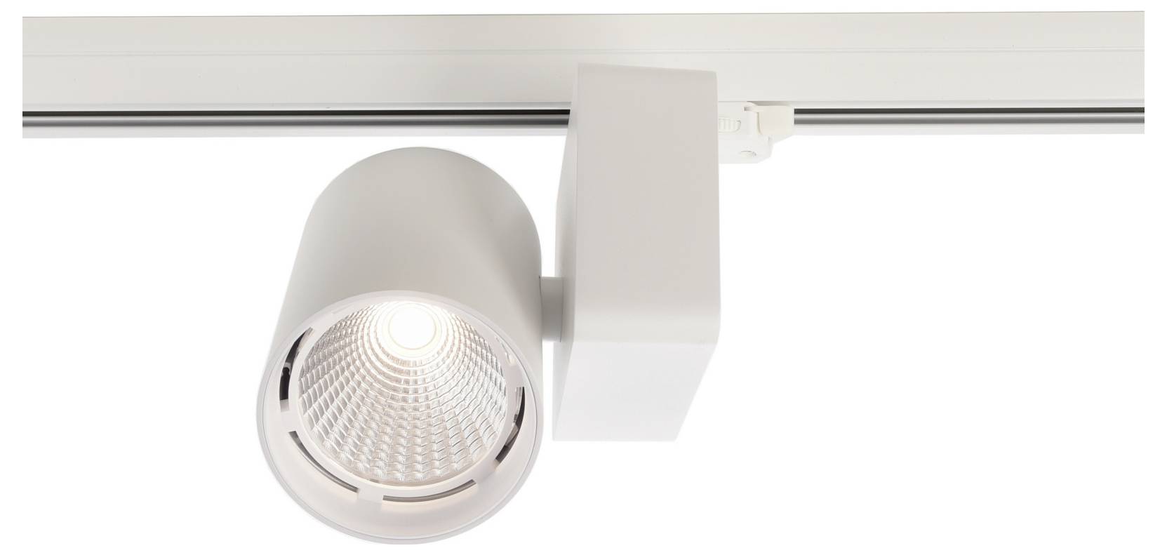 Spot réglable blanc sur rail, à tête cylindrique allumée, fixé à un rail de plafond.