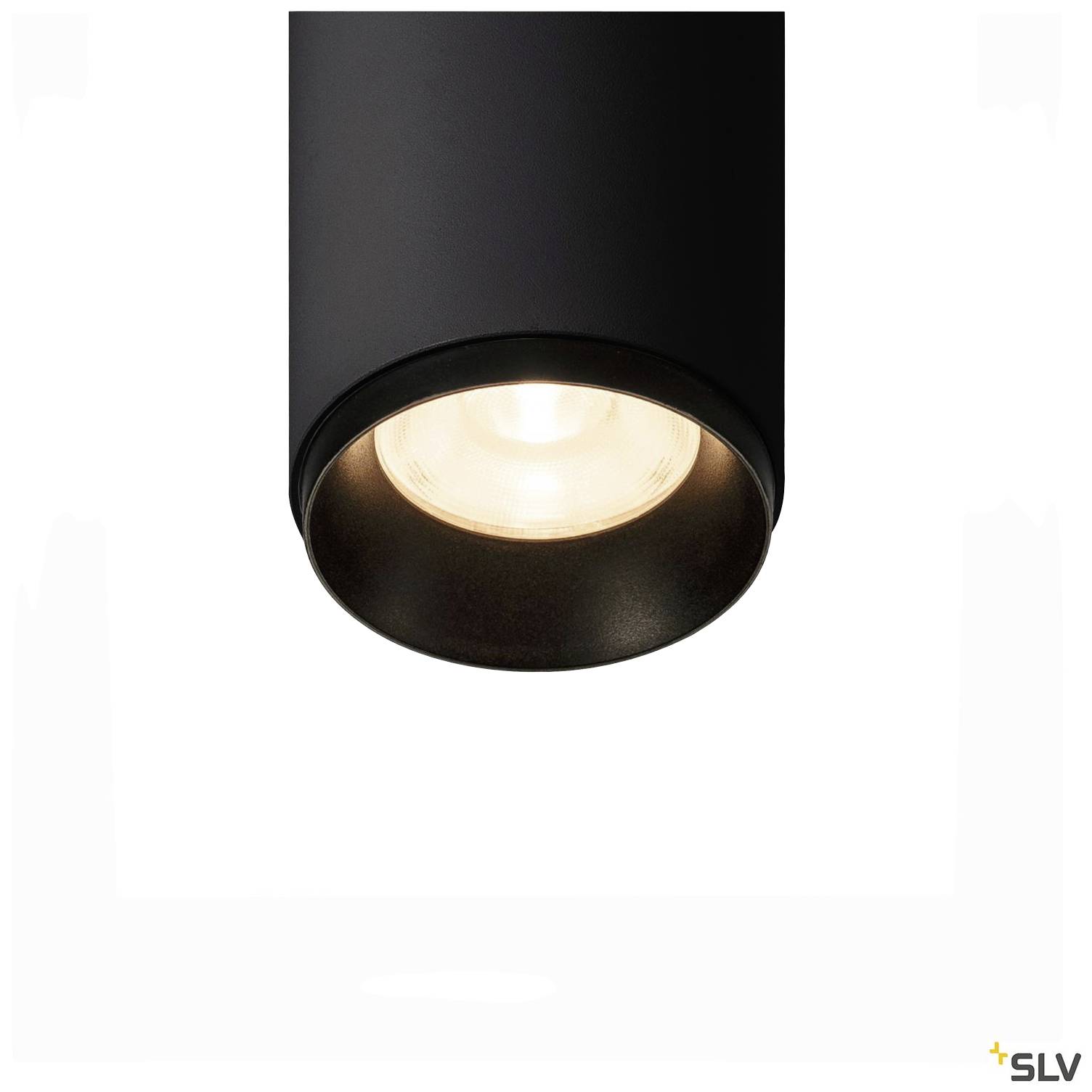 Un luminaire de plafond noir et cylindrique avec une ampoule apparente diffuse une lumière douce.