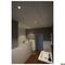 Une salle de bain minimaliste avec un lavabo, des murs blancs, un sol en bois brun et un éclairage discret au plafond.