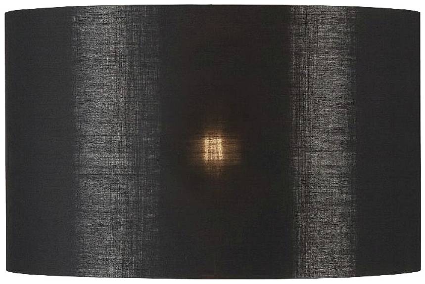 Abat-jour en tissu noir avec lumière chaude visible au centre.