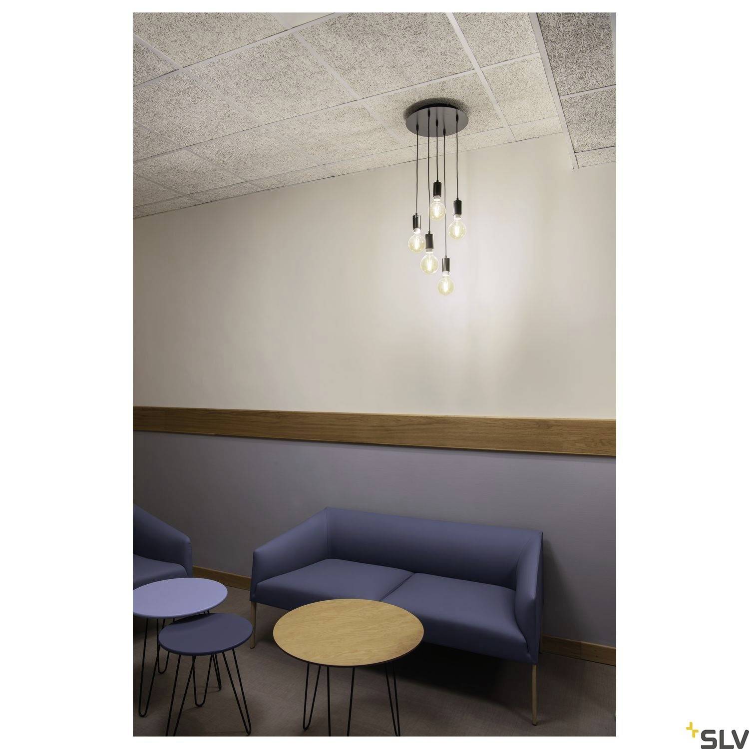 Un espace d'attente moderne avec un canapé bleu, des tables rondes et une suspension minimaliste à plusieurs ampoules au plafond.