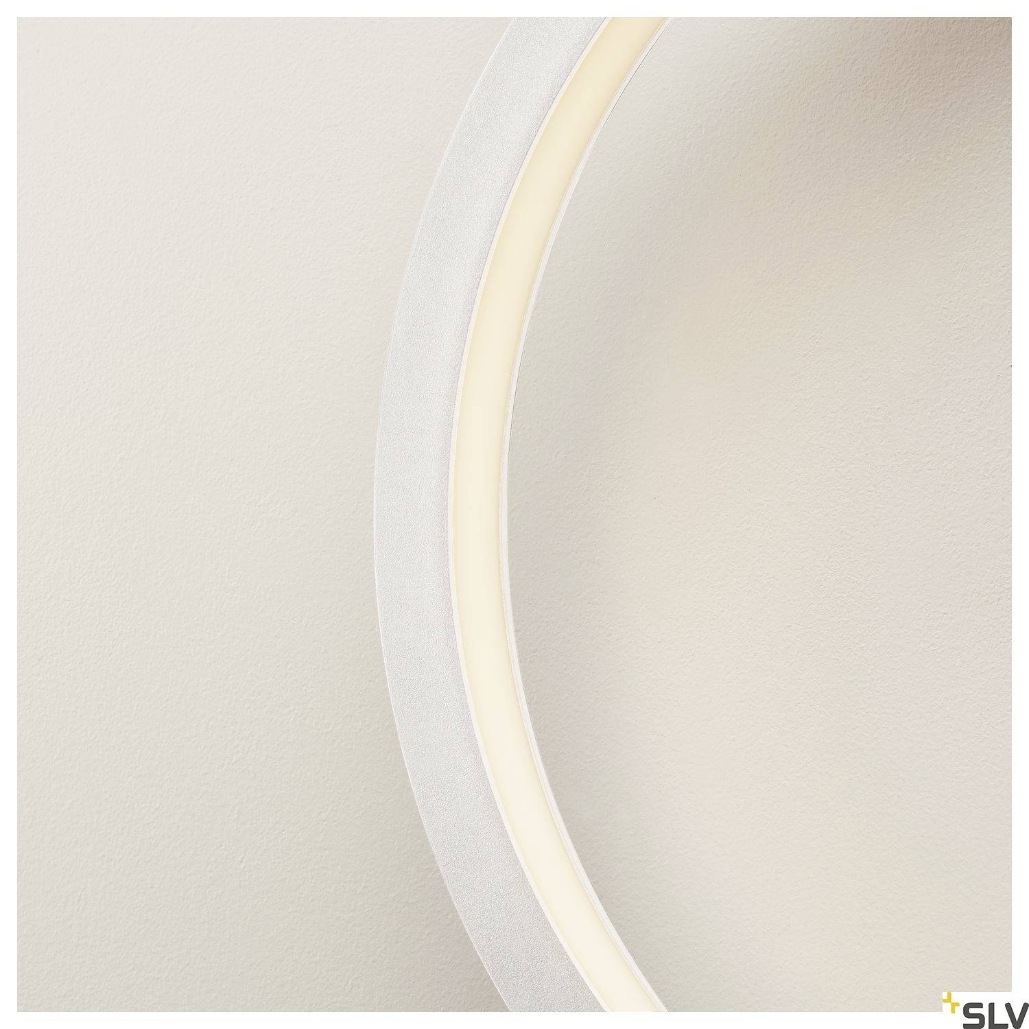 Un gros plan d'un segment de cercle lumineux sur une surface claire et texturée.