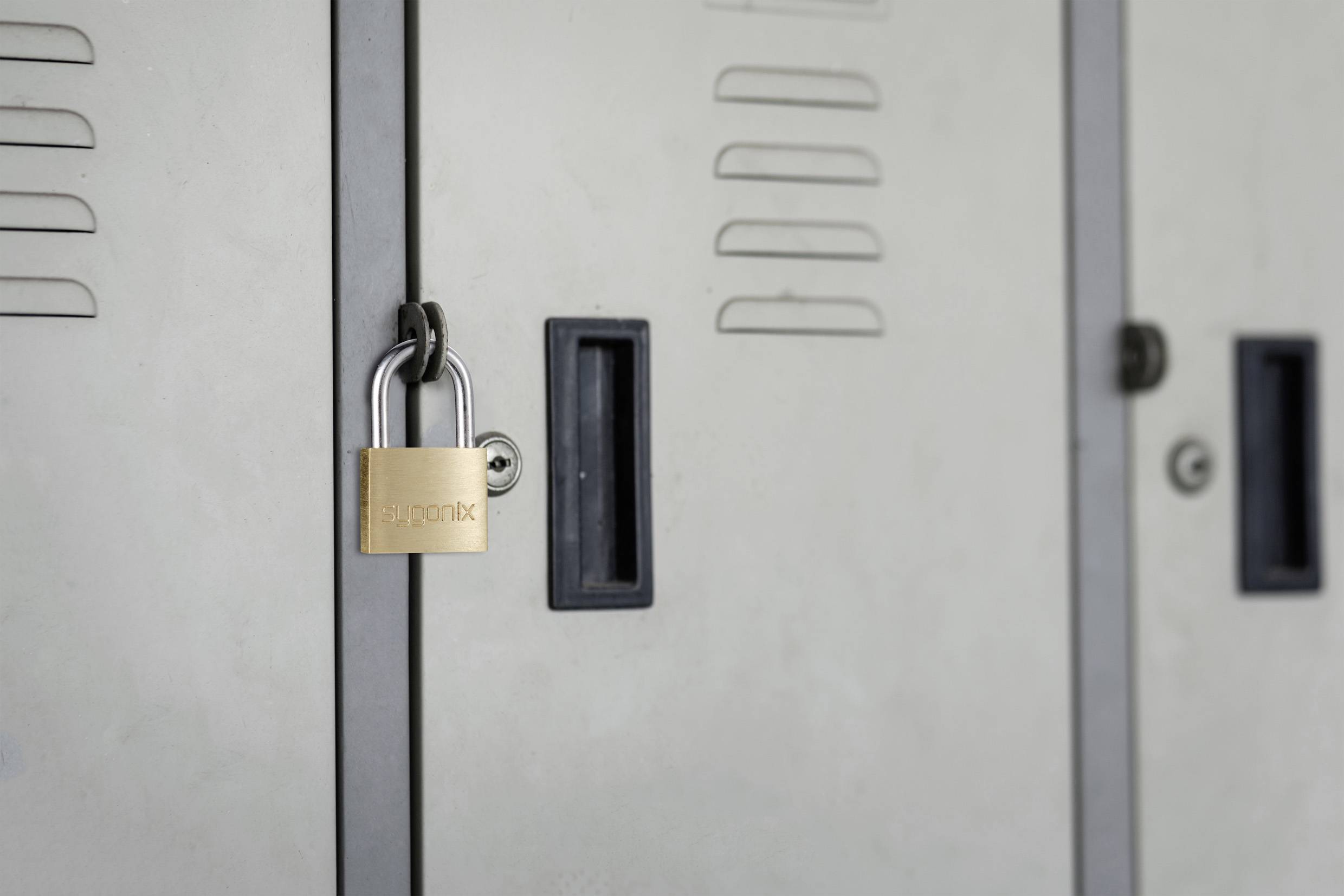 Un cadenas en métal argenté est accroché à un casier gris.