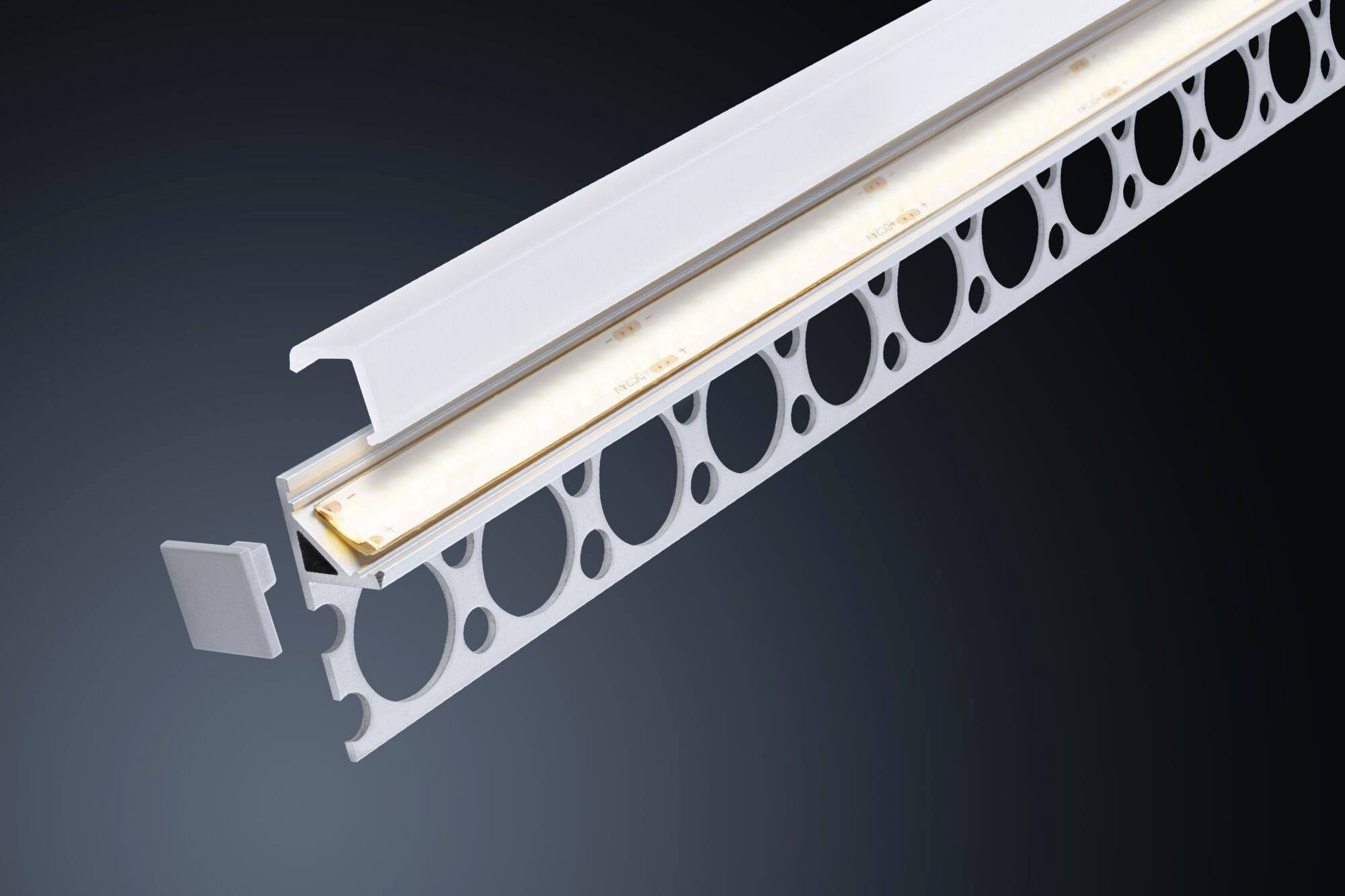 Un profilé en aluminium avec une barre LED montée, entouré de trous ronds. Il sert à fixer des bandes LED dans des constructions.