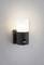 Lampe extérieure murale, avec un boîtier noir et un diffuseur lumineux cylindrique blanc, avec un détecteur de mouvement situé en dessous.