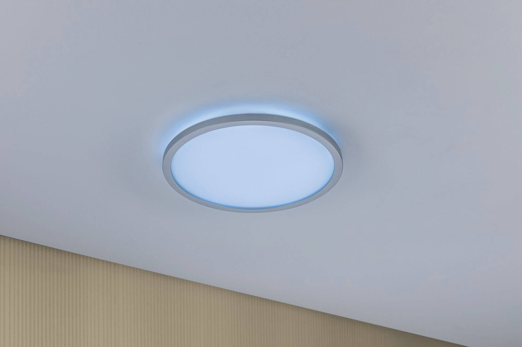Plafonnier LED rond fixé au plafond, émettant une lumière bleu vif. Design épuré, mettant en valeur l'aménagement intérieur moderne.