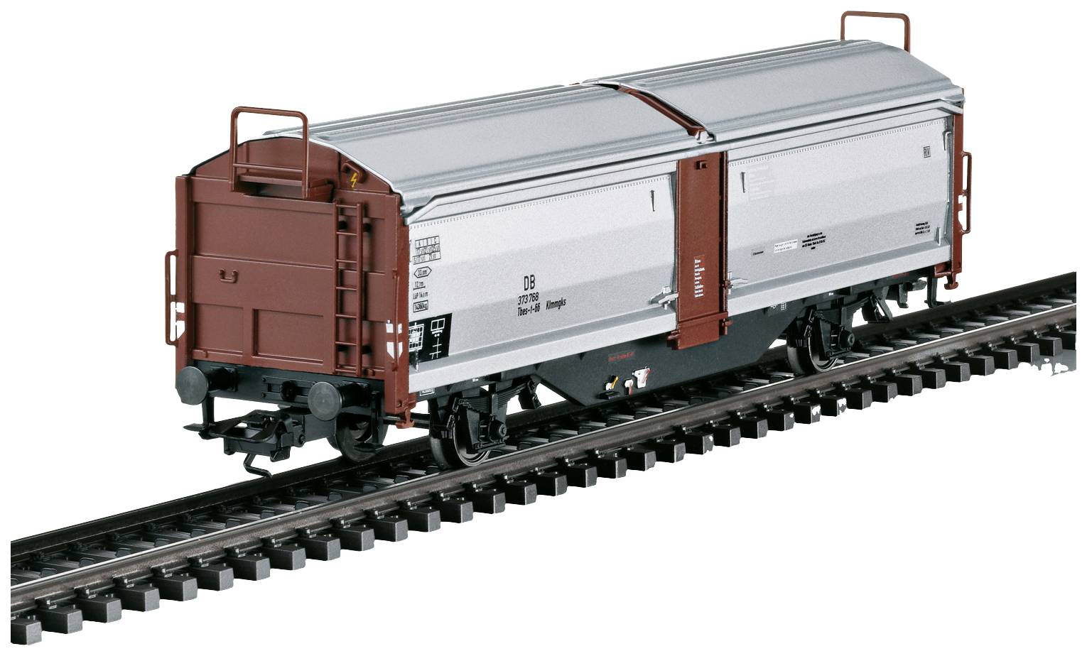 Un wagon de marchandises de train miniature sur un morceau de rail, avec des étiquettes détaillées et des roues en métal, présente un design très proche de la réalité.