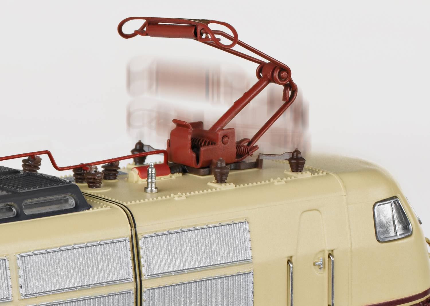 Un modèle beige-brun d'une locomotive électrique avec un pantographe relevé sur un fond blanc.