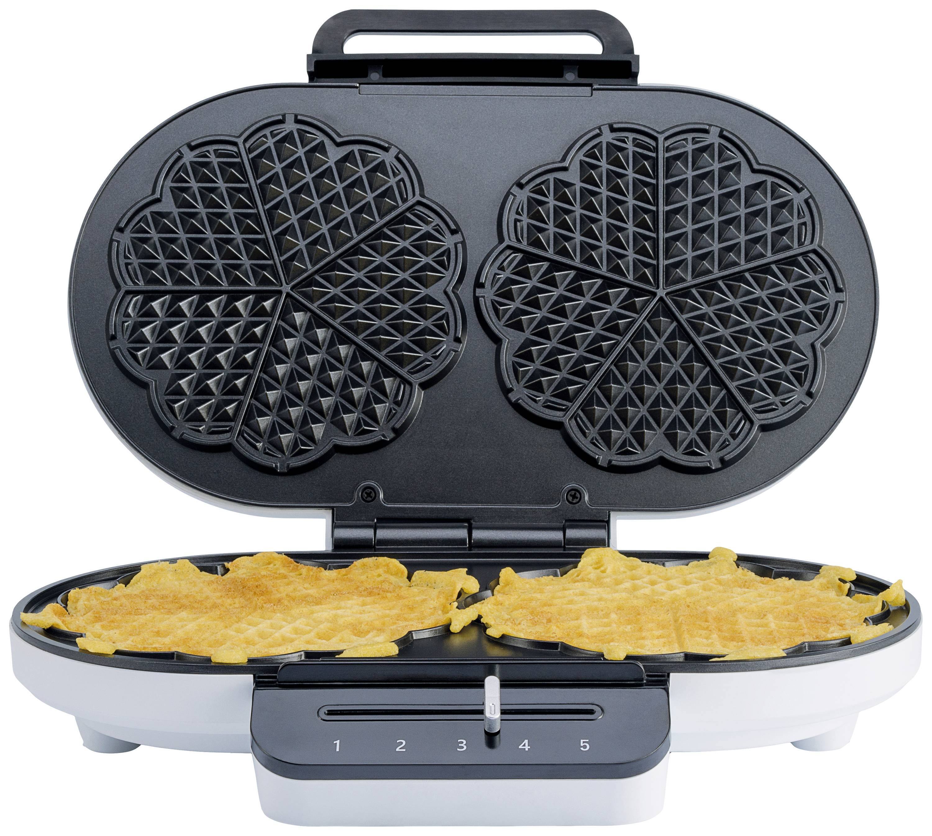 Un gaufrier avec deux gaufres en forme de cœur en cours de cuisson. L'appareil est équipé d'un bouton rotatif permettant de régler le niveau de brunissage.