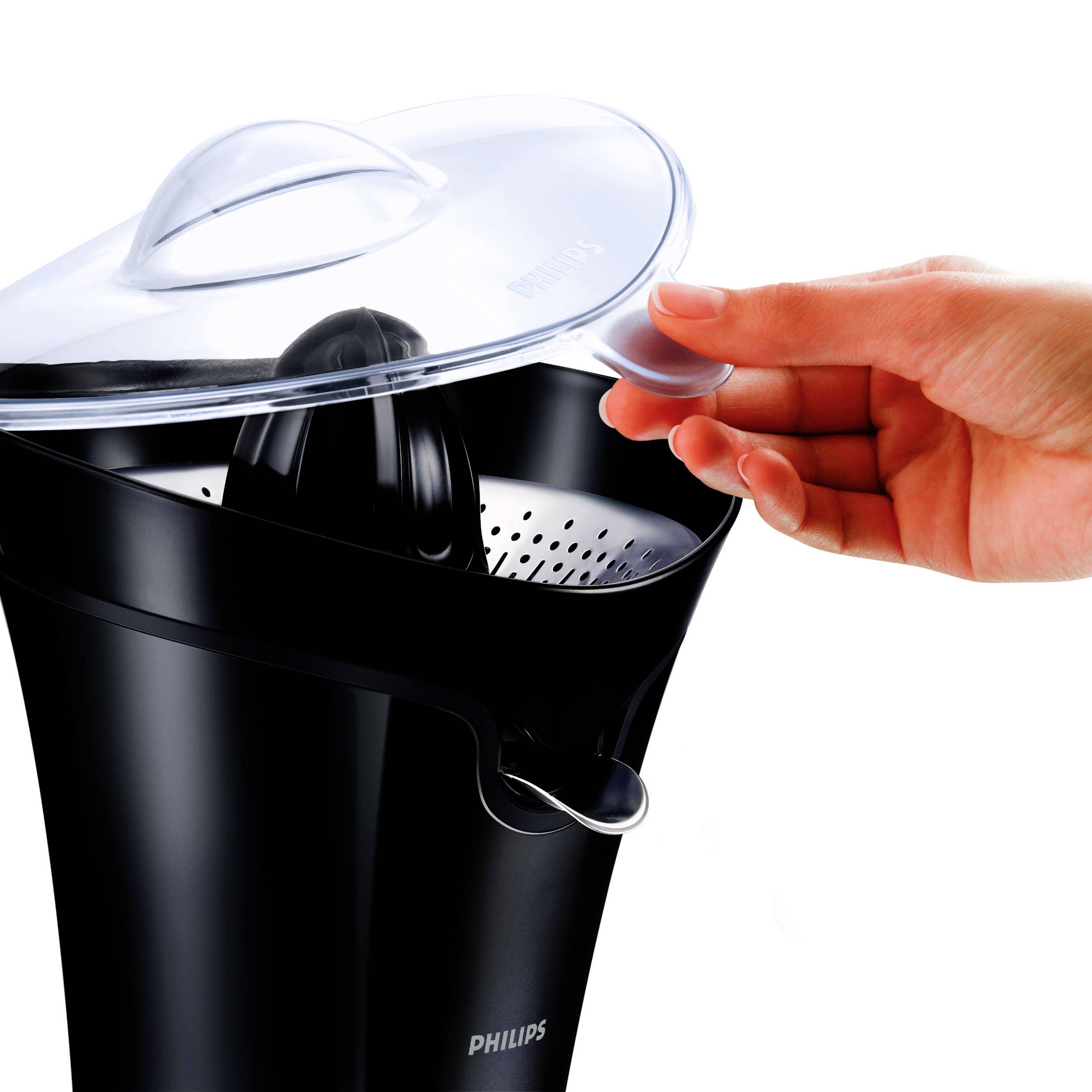 Une main soulève le couvercle d'un extracteur de jus électrique noir. L'extracteur de jus est de la marque Philips et présente une surface brillante.