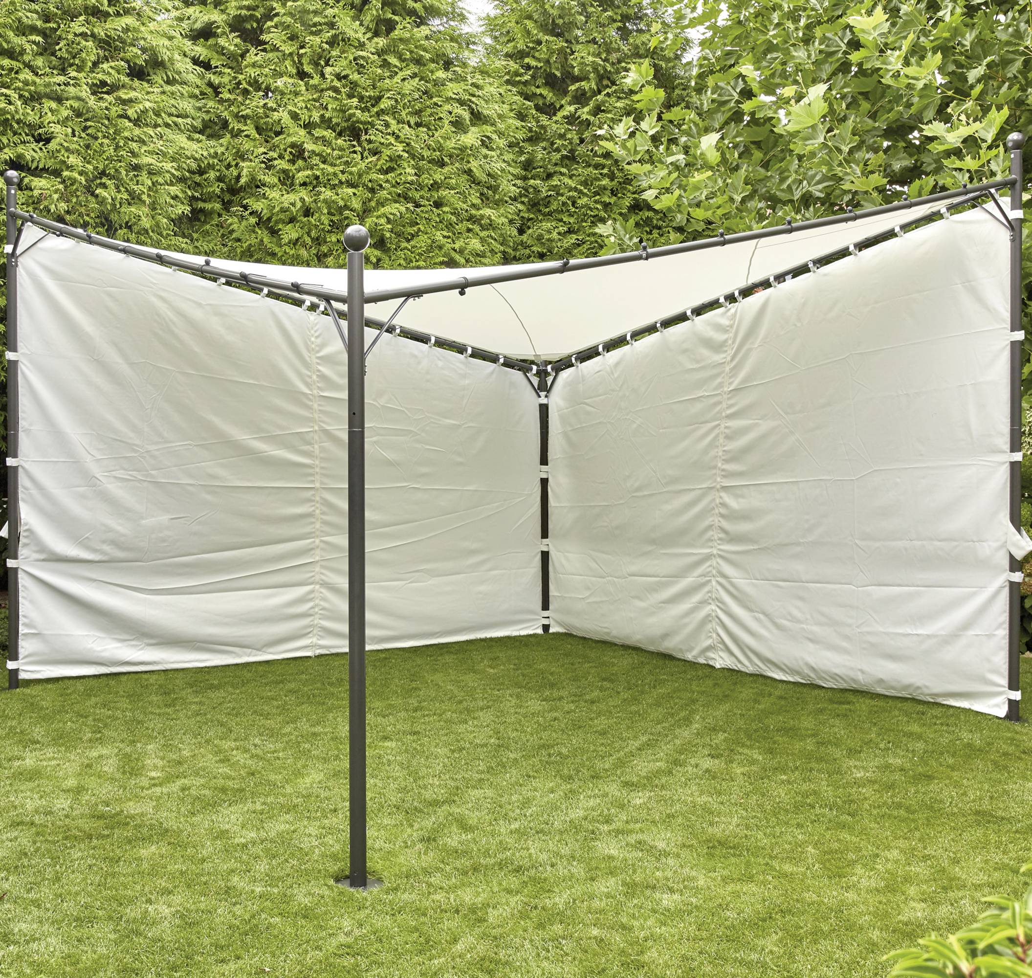 Pavillon à structure métallique avec des parois en toile blanche dans un espace de jardin sur une pelouse verte, entouré d'arbres de grande hauteur.