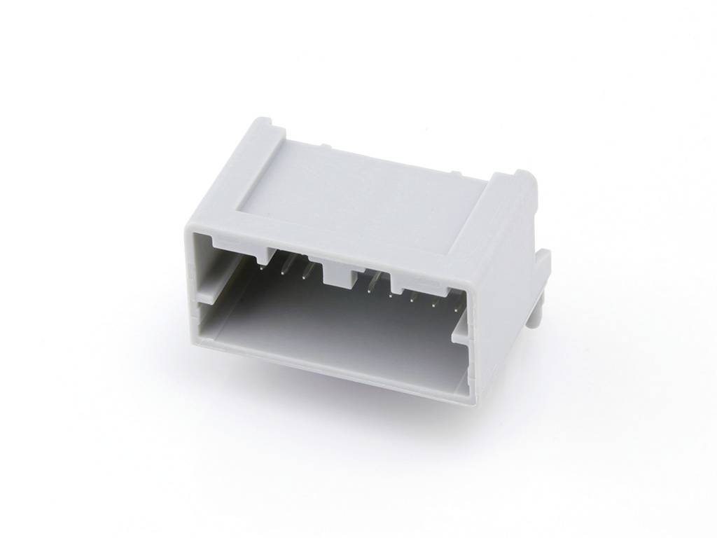 Un connecteur en plastique gris de forme rectangulaire avec plusieurs broches de connexion, isolé sur un fond blanc.