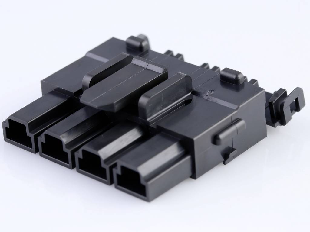 Un connecteur noir rectangulaire avec quatre emplacements sur une surface blanche.