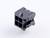 Un bouchon en plastique noir avec quatre ouvertures carrées et deux broches de fixation visibles sur une surface blanche.