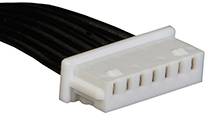 Un connecteur blanc multipolaire avec des câbles noirs, typiquement utilisé pour les connexions électriques dans les appareils électroniques.