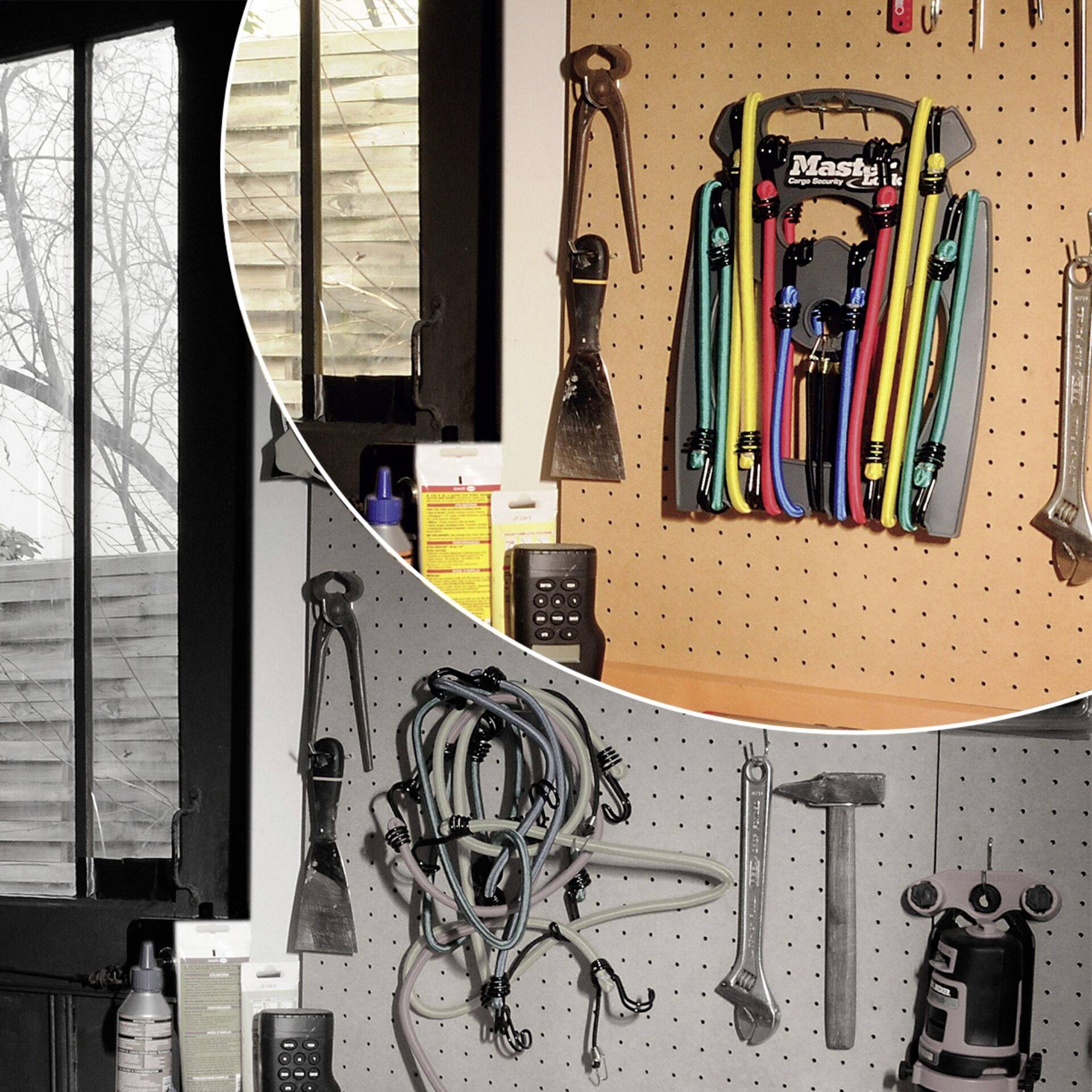 À gauche se trouve une fenêtre donnant sur des arbres dénudés. À droite, des sangles élastiques et des outils sont suspendus à un mur d'outillage.