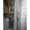 Un armoire métallique avec une porte grillagée est placée contre un mur de briques blanches. L'armoire est remplie de bouteilles de produits chimiques et sécurisée par un cadenas à combinaison.