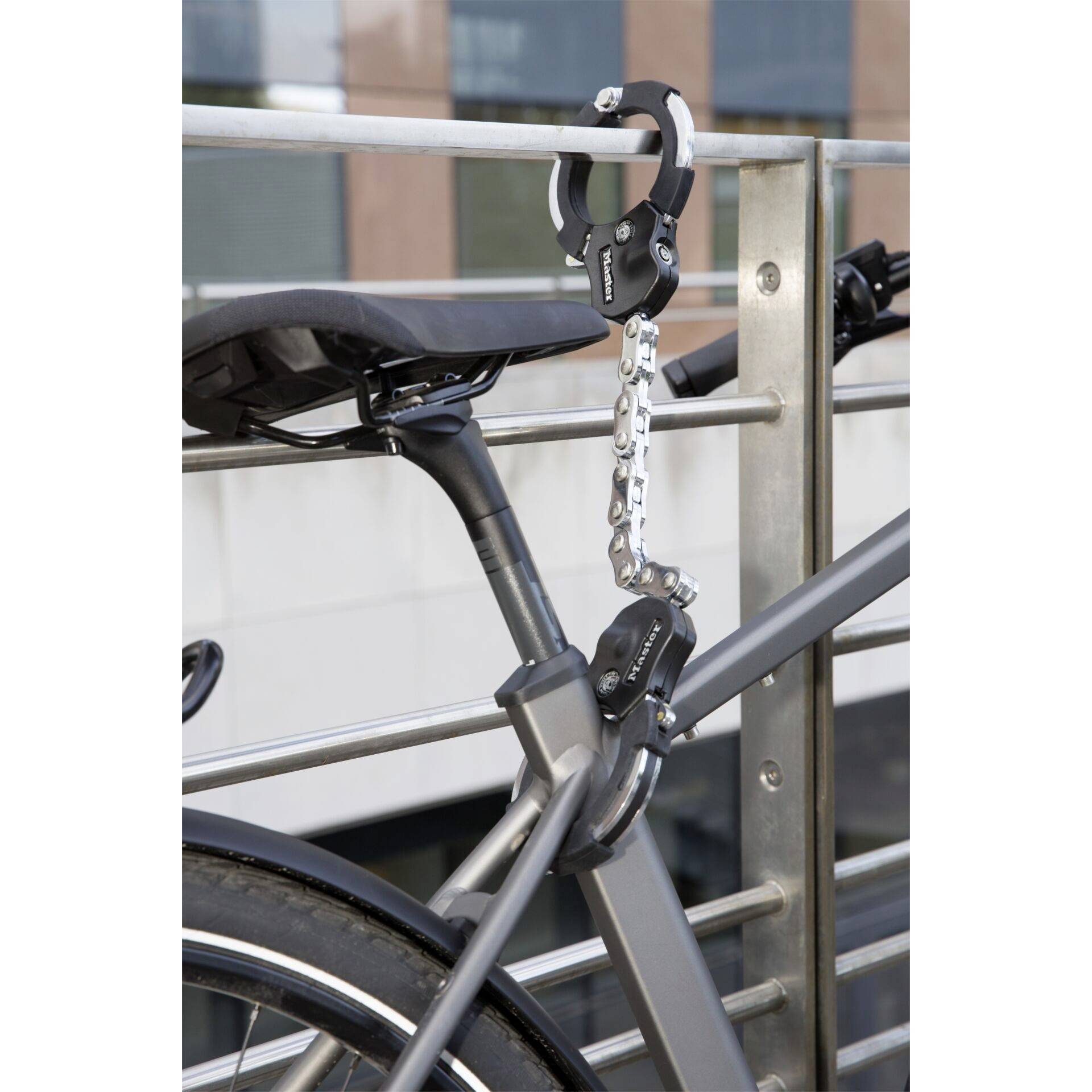 Un vélo attaché à une rambarde avec un cadenas. Le cadenas est fixé sur le cadre du vélo.