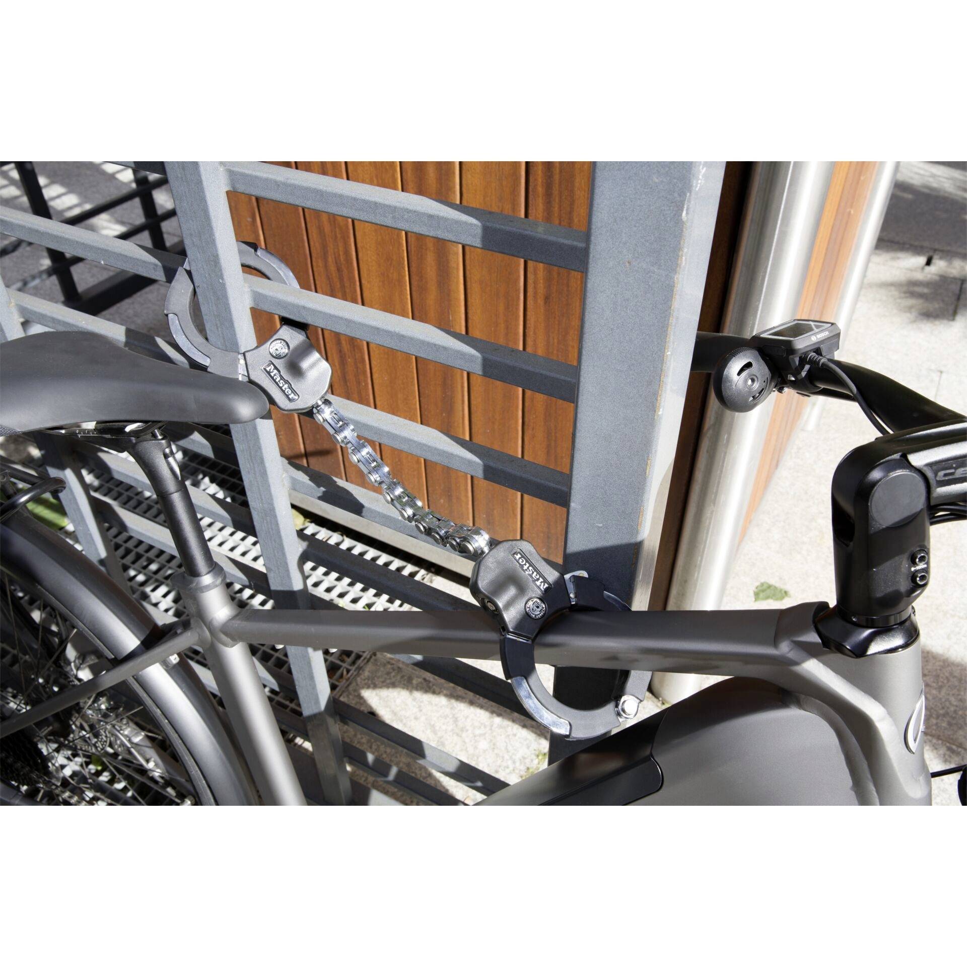 Bicyclette sécurisée par un antivol noir fixé à une rambarde métallique.