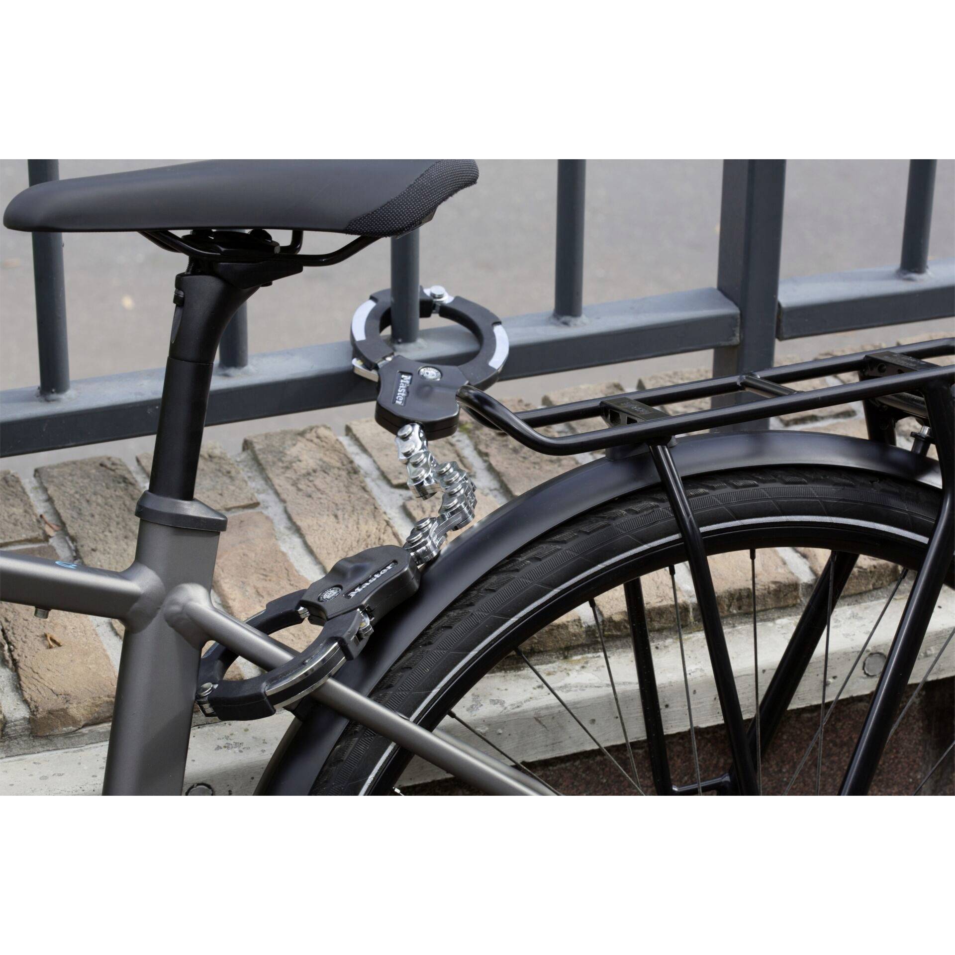 Un vélo est attaché à une rambarde métallique à l'aide d'un cadenas à code robuste. Le cadenas sécurise le cadre du vélo sur le support à vélos.