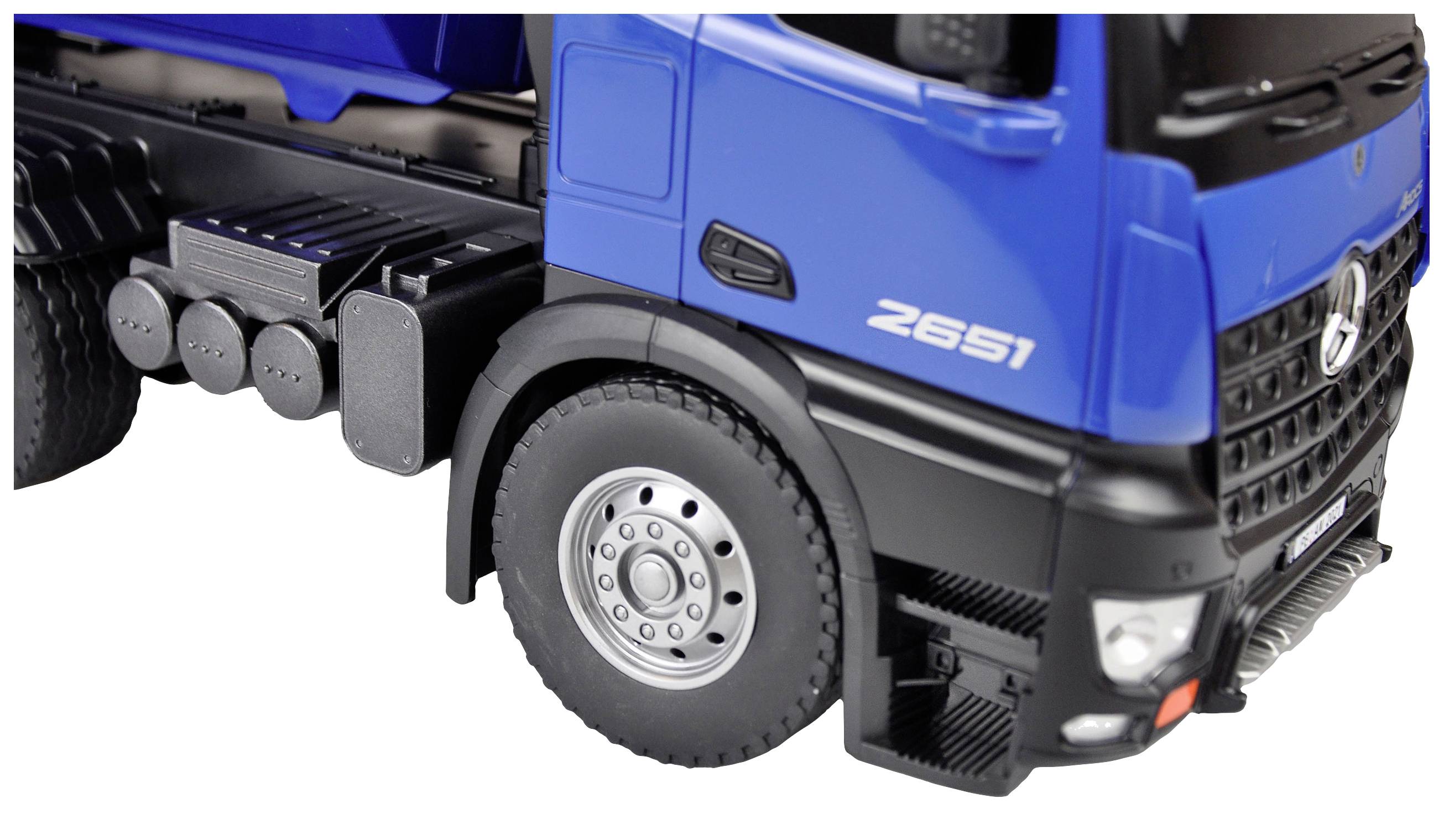 Camion bleu vu de profil, avec un focus sur le pneu avant et la cabine, illustrant une construction robuste et un design moderne.