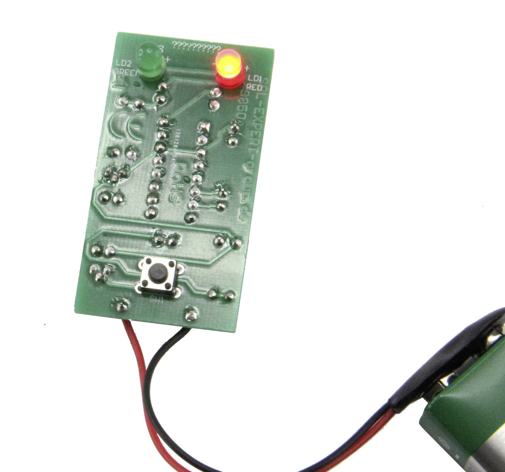 Une carte électronique verte équipée d'une LED rouge brillante et d'un bouton-poussoir est reliée à un câble.