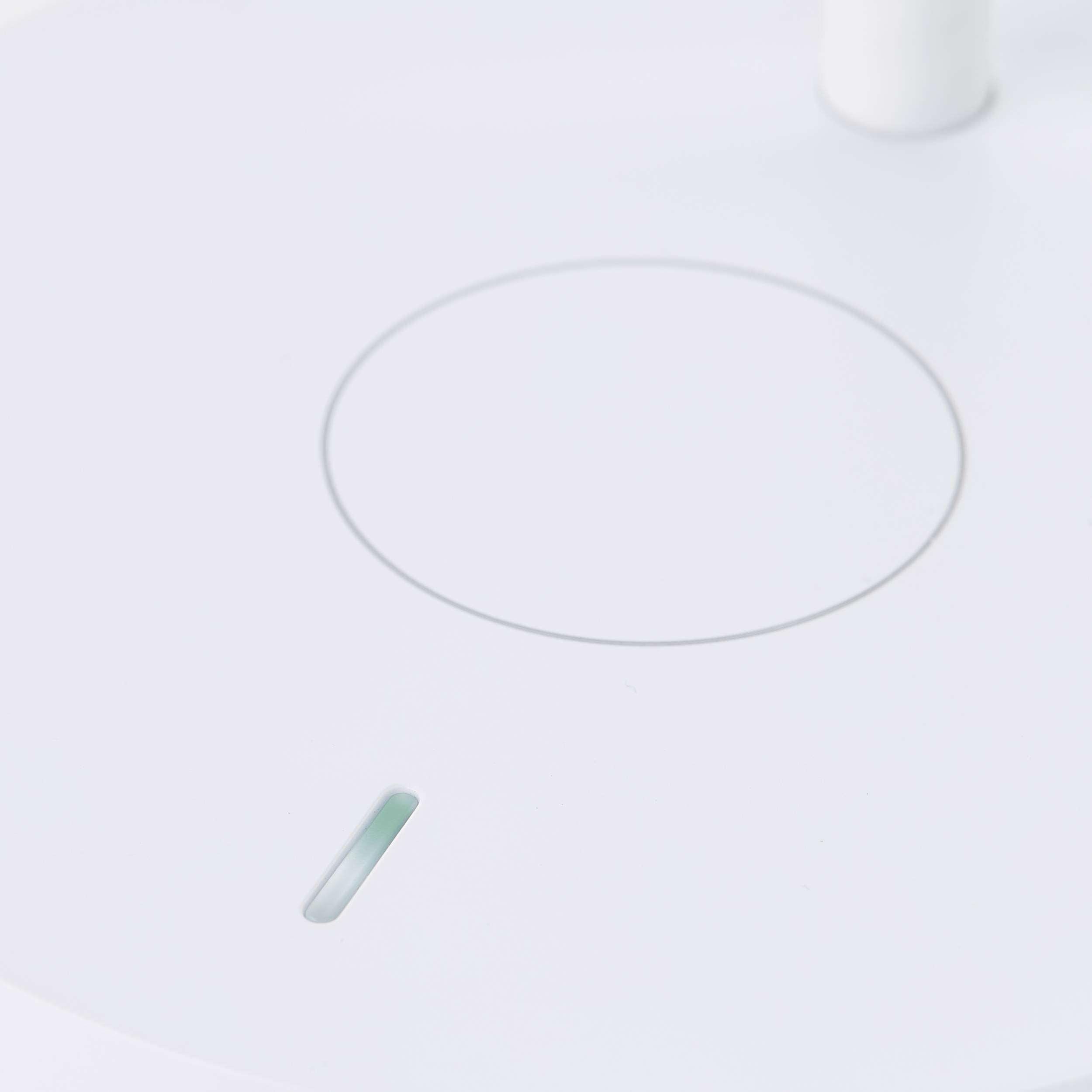 Un objet en verre avec un motif circulaire sur un fond blanc, probablement un élément d'un appareil moderne.