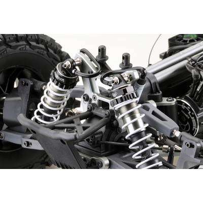 Gros plan sur le châssis d'une voiture miniature avec suspension et amortisseurs. On peut y voir la suspension de roue, les ressorts et différents détails techniques.