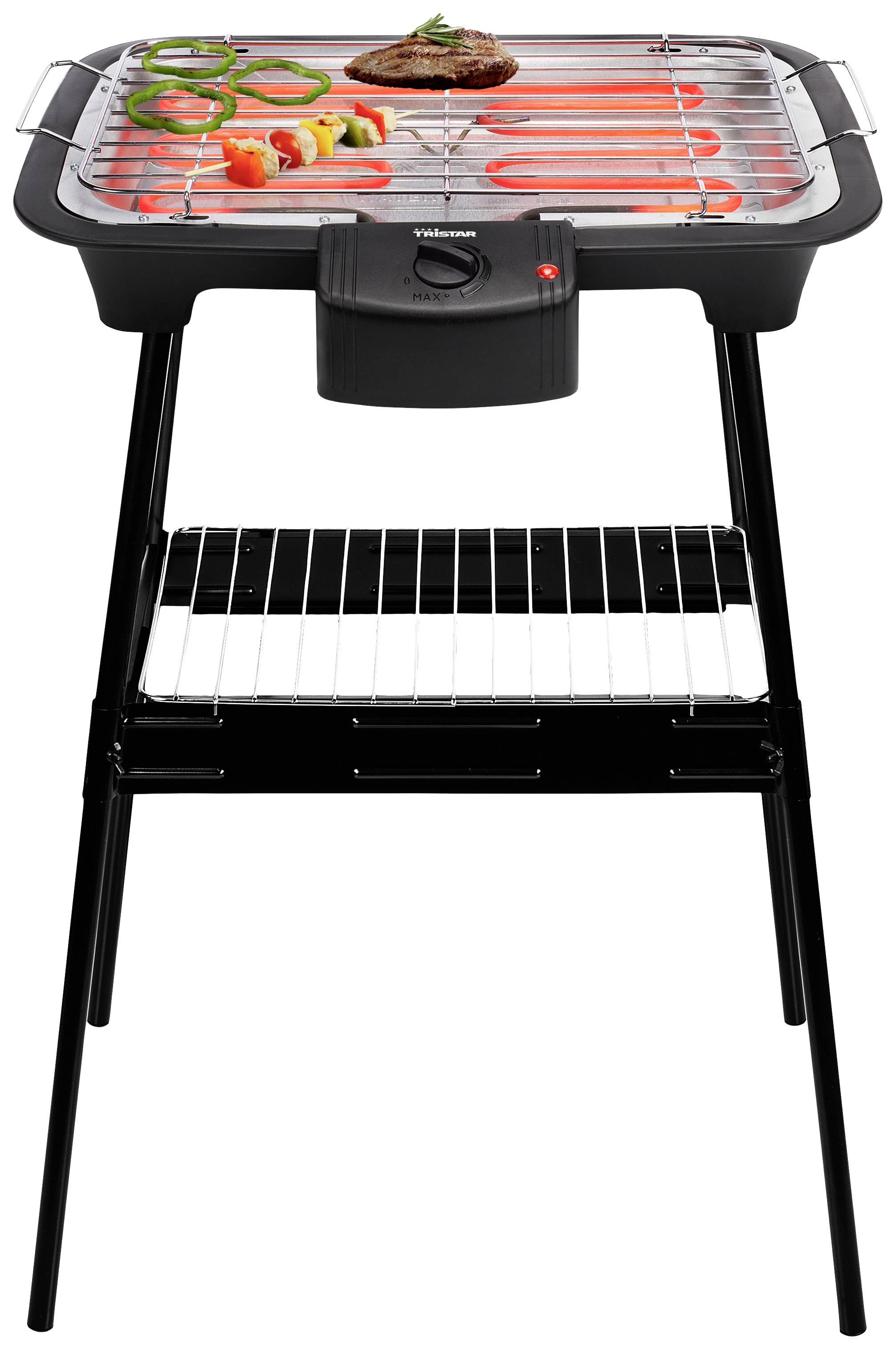 Grill électrique sur pied avec un steak grillé et des légumes, dont des concombres et des poivrons, sur la grille.