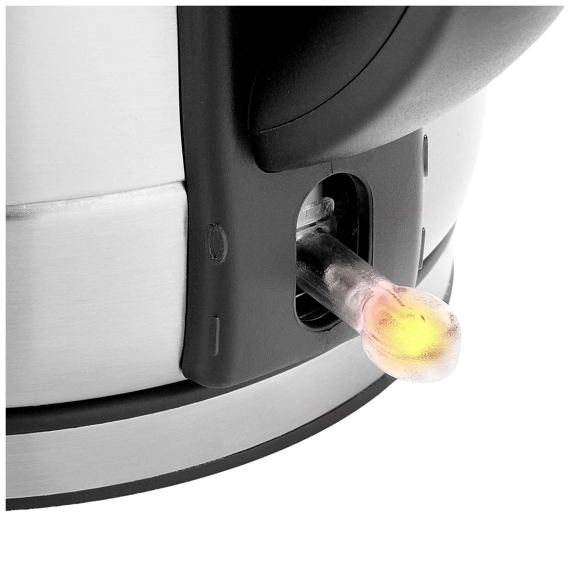 Une bouilloire avec un boîtier en acier inoxydable affiche un voyant LED incliné qui indique que l'appareil est en marche.