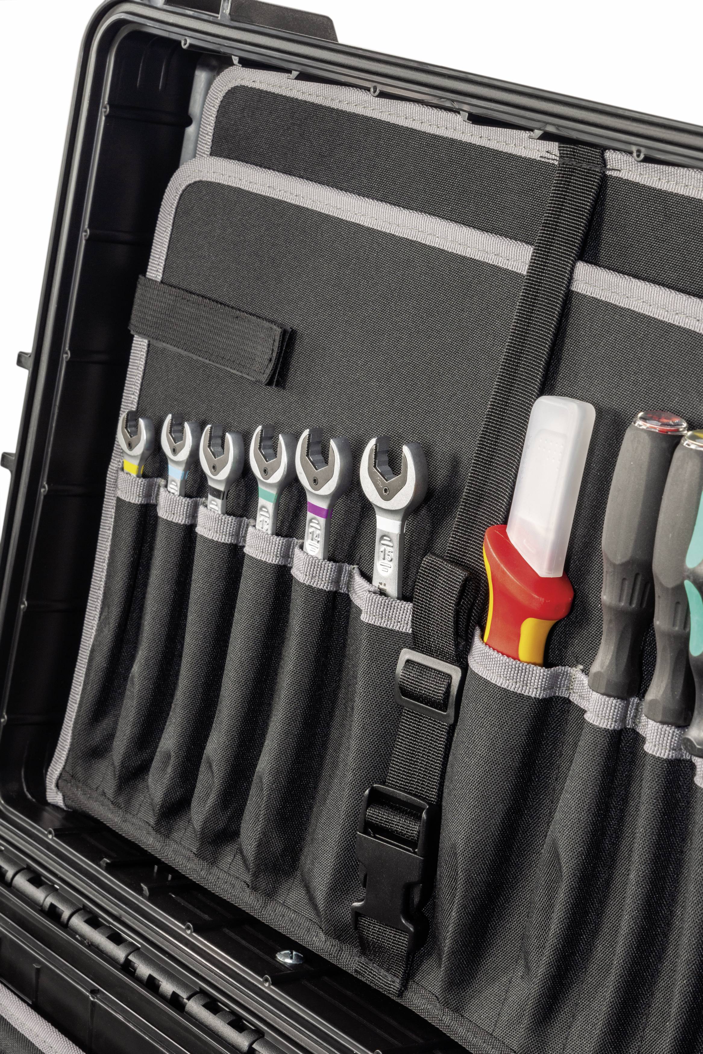 Une boîte à outils ouverte montre différentes clés et tournevis rangés dans des pochettes organisées.