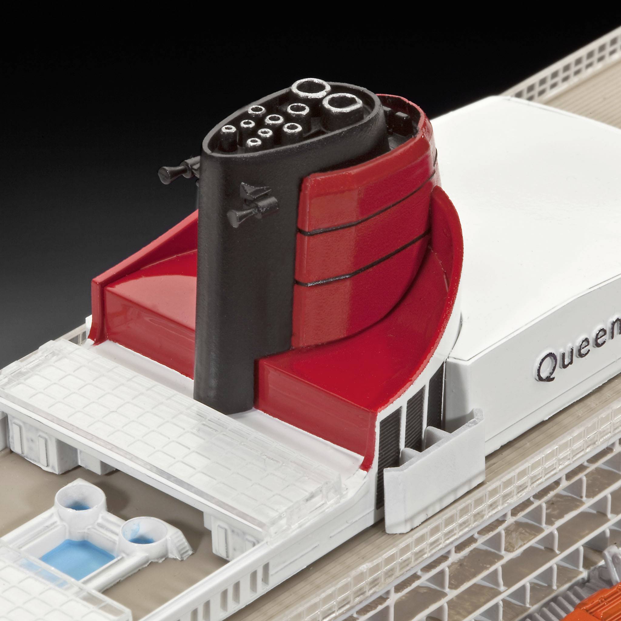 Modèle d'un navire blanc avec des cheminées rouges et noires, reconnaissable à l'inscription 'Queen Mary'.