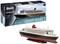 Kit de maquette plastique du 'Queen Mary 2' à l'échelle 1:700 par Revell. Présente le navire flottant, avec l'illustration de la boîte en arrière-plan. Convient à partir de 12 ans.