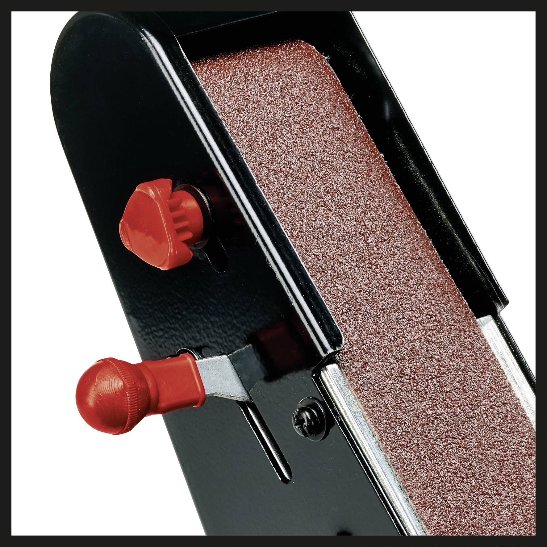 Un outil noir avec une surface de ponçage rouge-brun, deux boutons rouges sur le côté ; probablement un appareil de ponçage.