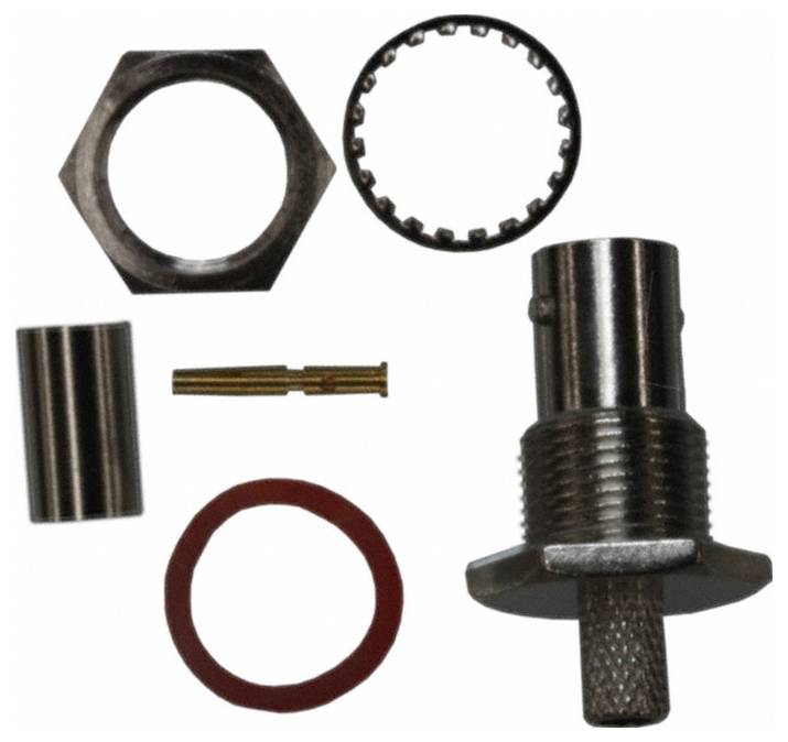 Un composant électronique cylindrique avec des broches métalliques sur le dessus et « corcom » imprimé sur le côté, probablement un filtre ou un condensateur.