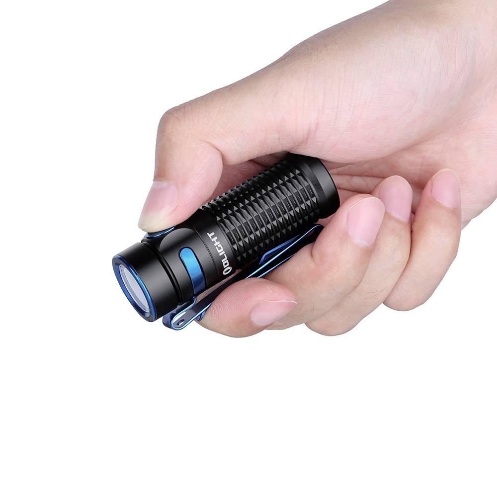 Une main tient une petite lampe de poche noire avec des accents bleus et une surface texturée.