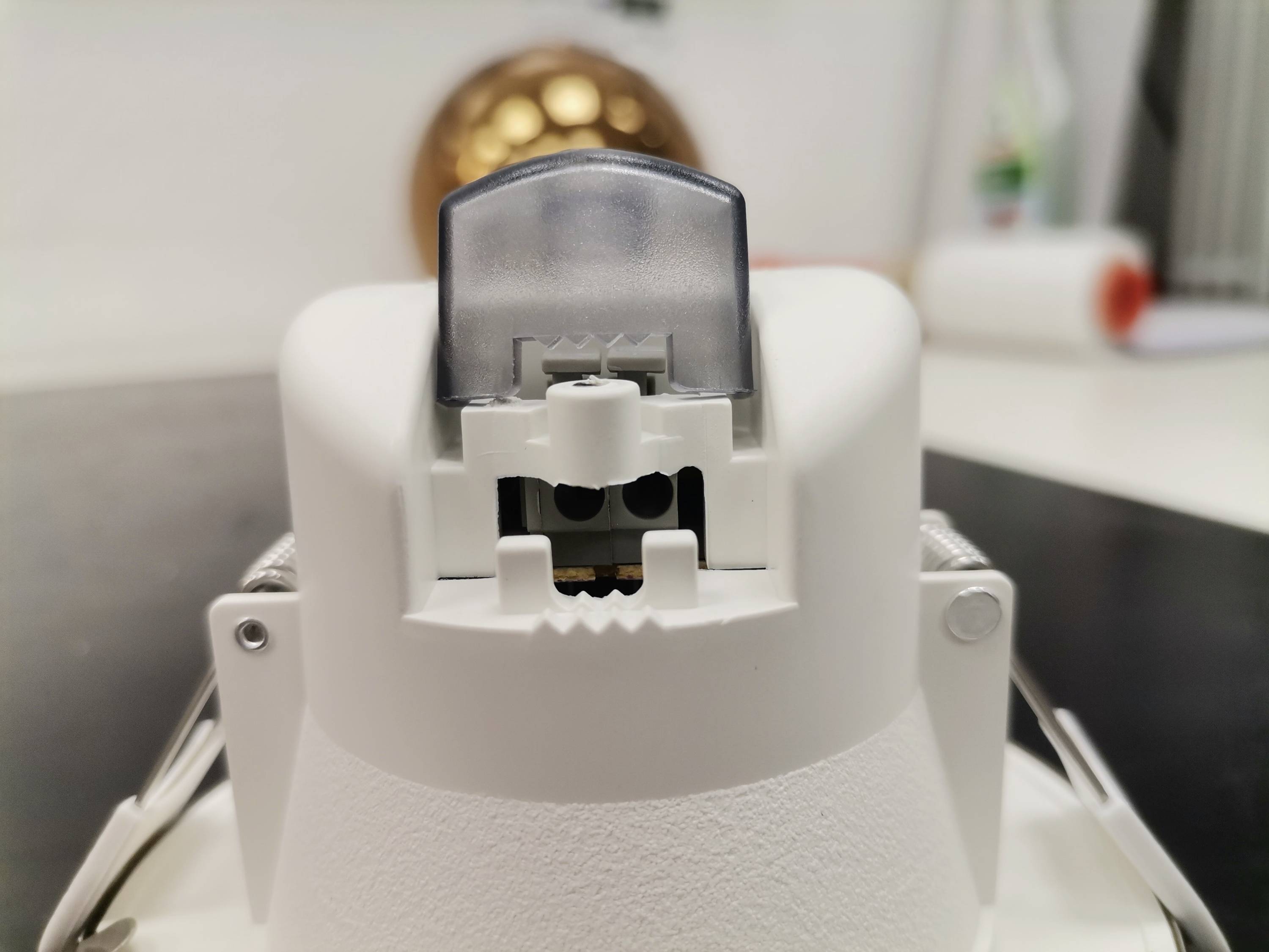 Gros plan d'un appareil blanc avec une partie supérieure transparente en plastique, placé dans une cuisine moderne.