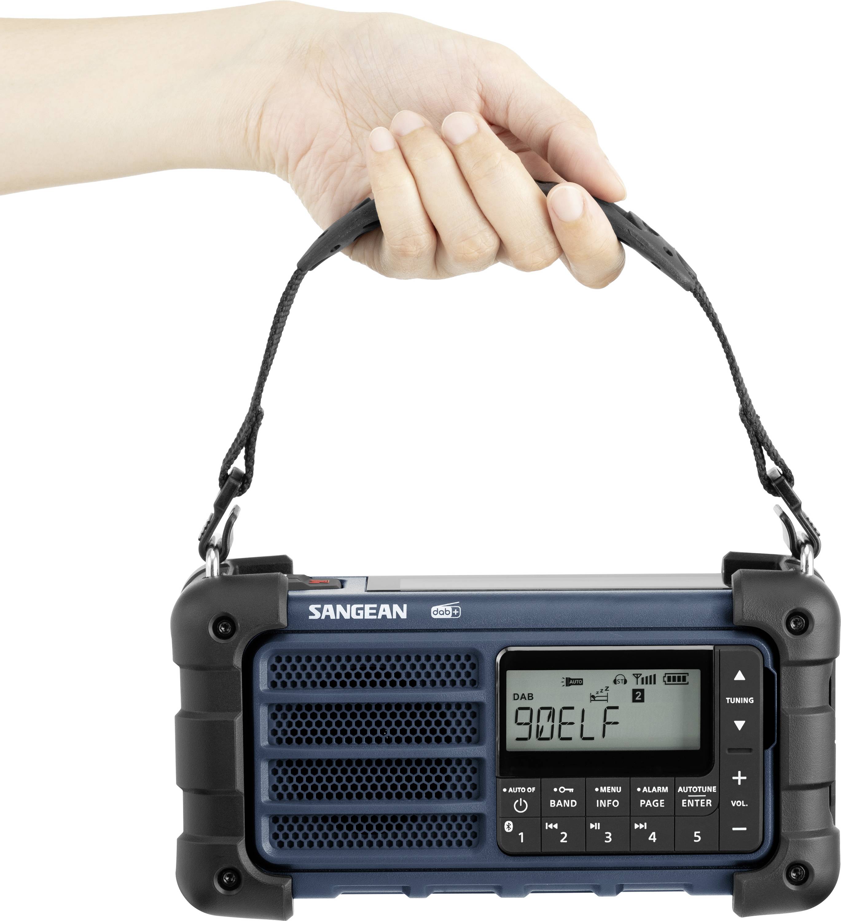Une main tient une radio portable avec une poignée en cuir noir. La radio affiche un écran numérique et des touches pour les réglages et la sélection des stations.
