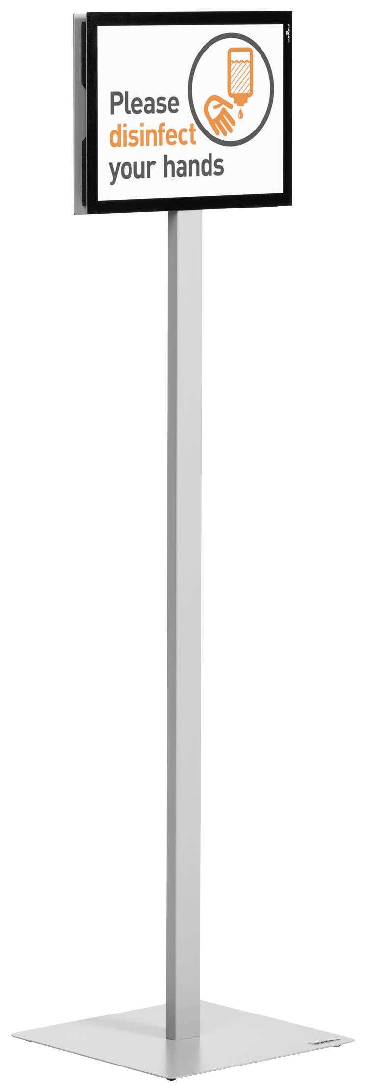 Panneau avec l'injonction 'Veuillez désinfecter vos mains' et une image d'une main avec un désinfectant. Placé sur un support.