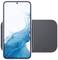 Un smartphone au bord bleu affiche un design abstrait bleu sur un fond blanc. Il est posé sur un chargeur plat gris.